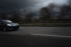 black car at high speed on road