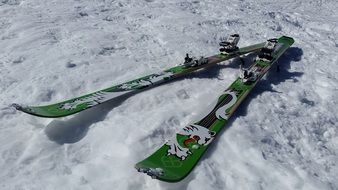 green tourist skis in the snow