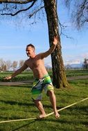 man balancing along a flat webbing