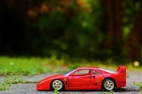red toy car in the park among beautiful nature