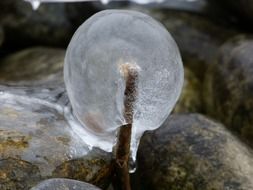 a piece of ice lies on the rocks in nature