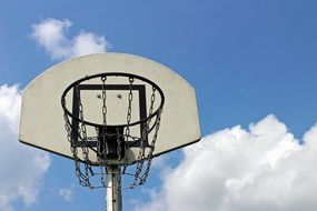 basketball basket against the blue sky with white clouds