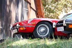 red and black oldtimer sports cars on grass
