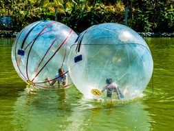 people in ball on the water as extreme
