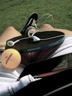ping pong ball and racket on person’s lap