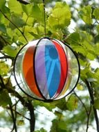 colorful children's ball on a green tree closeup