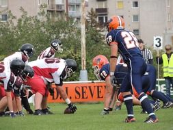 athletes in protective clothing in american football on a match