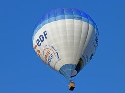 flying hot air balloon against a clear blue sky