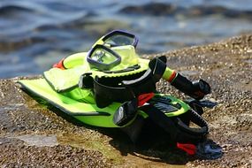 snorkel diving equipment on stone at water