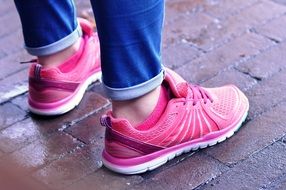 pink sneakers on the legs of a girl