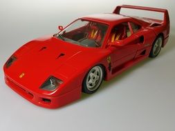 Red ferrari car model on white surface