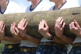 navy men holding log, training