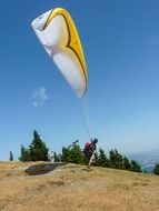 paraglider stands on hill, austria, sankt radegund