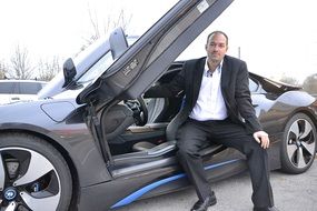 Man at a sports car of a class lux