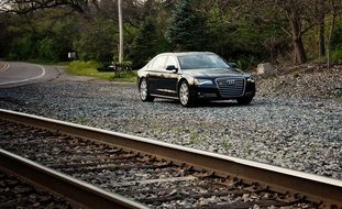 Luxury sports car near railway rails