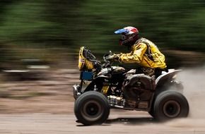 racer on atv vehicle speeding on soil road