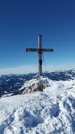 Christian cross stands on a snow-covered mountain