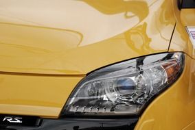 headlight of a yellow sports car close up