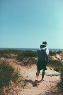 a man in a sweatshirt runs down the hill