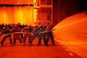 firefighters hold fire hose