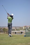 woman kicks the ball with a golf club