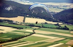 flying paraglider above summer countryside