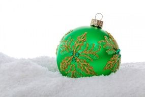 green christmas ball in the snow