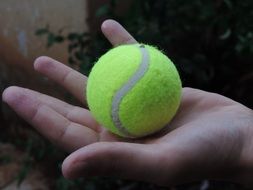 tennis ball on a manâs hand