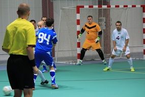 The referee watches the game of football in the hall