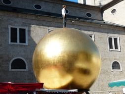 man stands on a golden ball