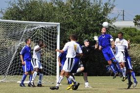 football players with the ball near the gate