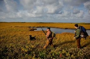 men on a hunt with a dog