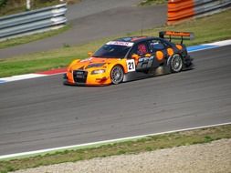 racing car on the track near the fence