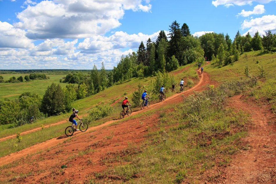 people riding bikes along the mountainside