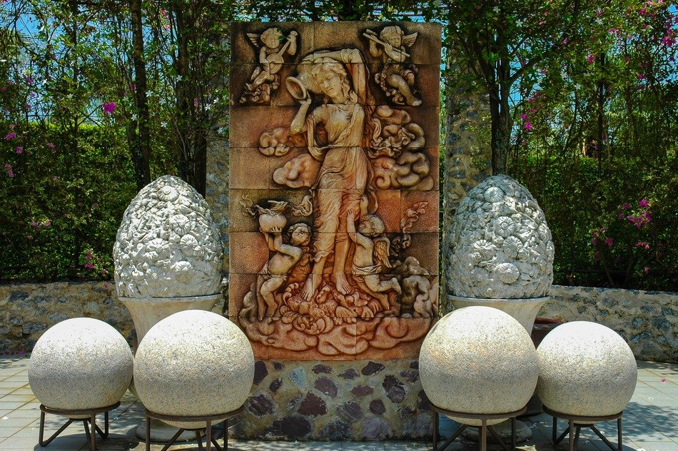 stone balls in front of relief with woman and winged kids in park