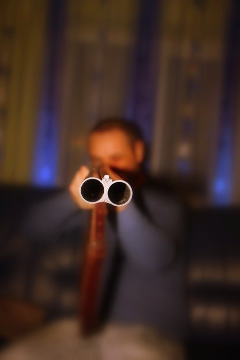 guy points the shotgun forward