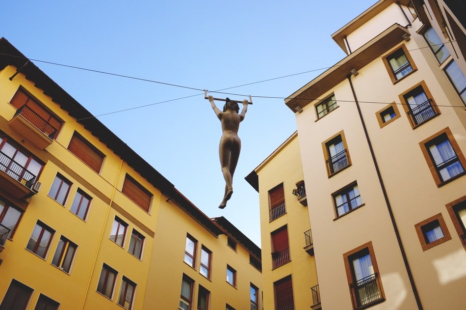 aerial gymnast on a tightrope between houses