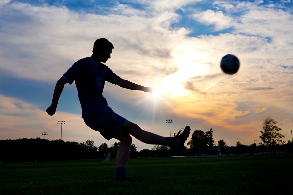 the footballer is playing in the sunset