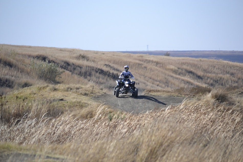 man rides quad in wilderness