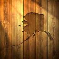 Alaska Map on lit Wooden Background
