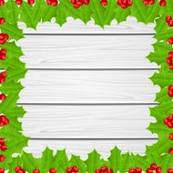 Christmas frame of holly berries on wooden background