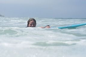 girl on a blue surfing board in the ocean