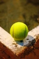 Yellow tennis ball on parapet