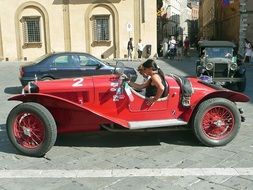 girls in red oldtimer siena auto on street