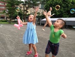 children burst soap bubbles