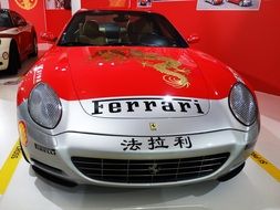 Front view of red Ferrari with symbols and inscriptions on the hood