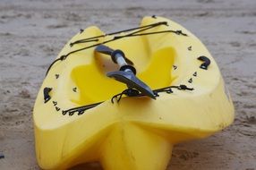 yellow kayaking boat with paddle on the beach