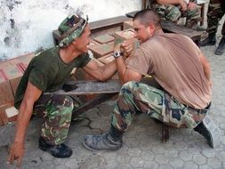 happy military men arm wrestling for fun