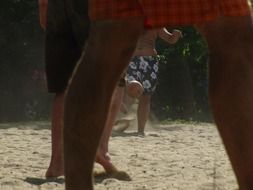 feet of players in a soccer game on the beach