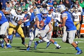 football players in american football on green field